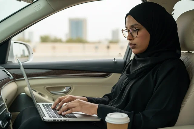 African Woman in Abaya Using Laptop Inside a Car