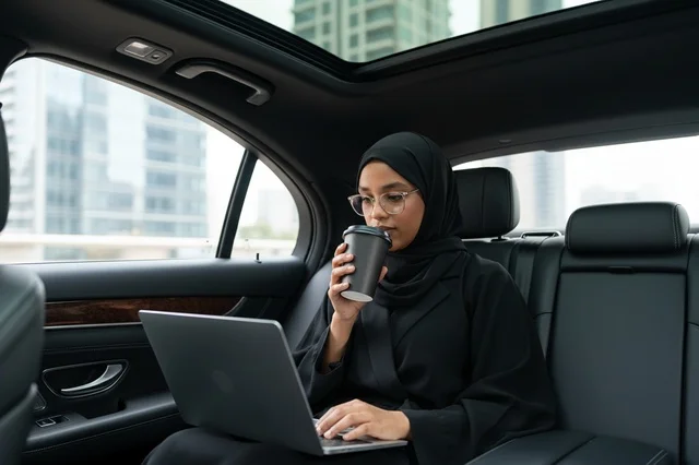 Emirati Businesswoman Working on Laptop in Luxury Car