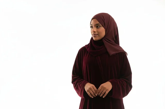 امرأة بعباءة مخملية خمرية وحجاب خلفية بيضاء