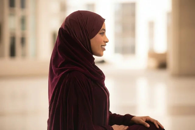 امرأة مسلمة ترتدي خماراً عنابي اللون جانبي