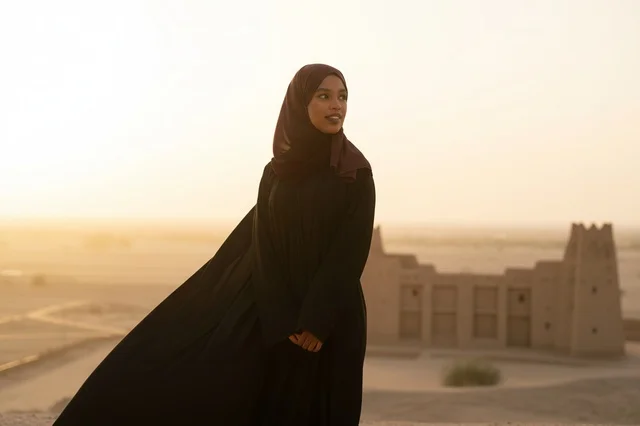 امرأة سعودية بالعباءة في موقع تراثي صحراوي