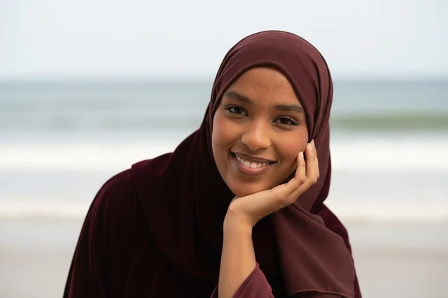 Smiling Somali Woman in Maroon Hijab at the Beach Shore