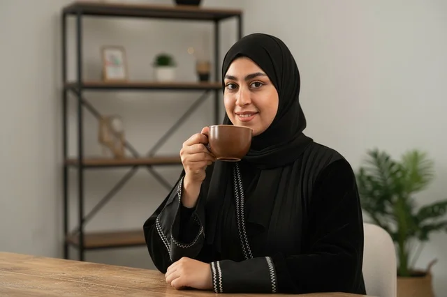 Emirati Woman in Abaya Drinking Coffee Indoor