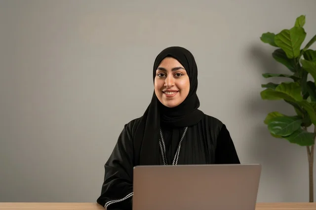 Saudi Businesswoman in Abaya Using Laptop in Office