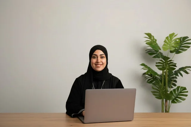 Emirati Woman Using Laptop in Modern Office