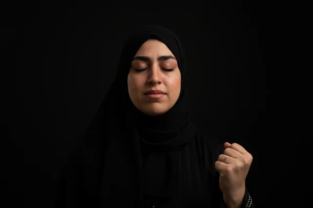 امرأة عربية تبكي بالحجاب على خلفية سوداء