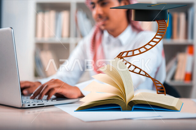 طالب جامعي عربي خليجي سعودي مبتسم يستخدم الحاسوب المحمول داخل المكتبة الجامعية، بجانبه كتاب وسلم يصل لقبعة التخرج ، النجاح والتخرج الجامعي ، اعداد بحث التخرج ، الدراسة والتعليم الالكتروني ، النجاح والوصول الى الهدف 