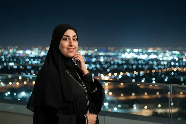 Emirati Woman in Black Abaya Overlooking City at Night