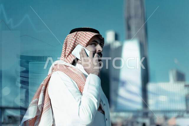 رجل اعمال عربي خليجي سعودي مبتسم يقوم باجراء مكالمة هاتفية مع خلفية مدموجة بالعملات المعدنية والرسم البياني لسوق الاوراق المالية ، مناقشة النمو والارباح المالية ، ادخار وتوفير الاموال ، ادارة الاعمال والاستثمار