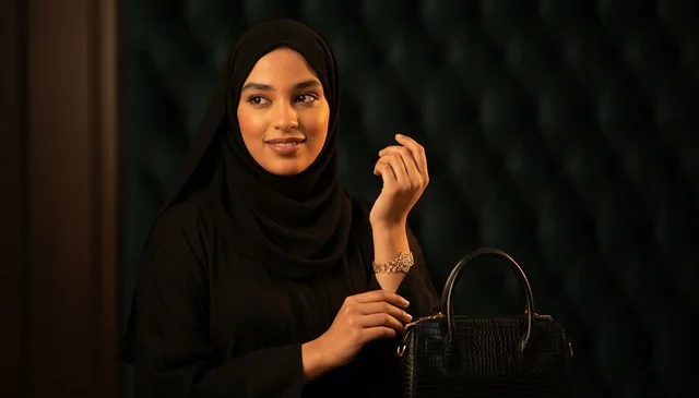 امرأة سعودية بالعباءة السوداء مع حقيبة يد فاخرة