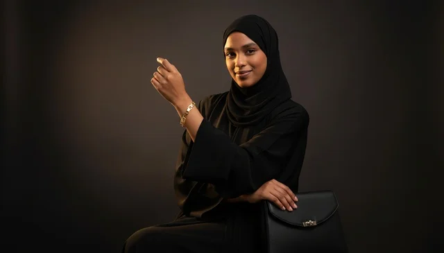 An Emirati woman in a black abaya carrying a luxury handbag.