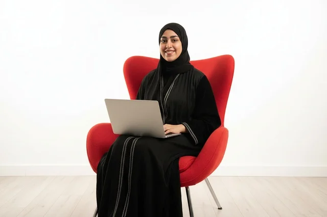 Saudi Woman with Laptop in Modern Red Chair