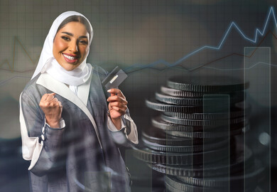 A Saudi Arabian Gulf businesswoman holding a bank credit card in her hand, electronic shopping, the success of the buying and selling process, electronic payment card, electronic payment via the Internet, financial investment, background of coins and the 