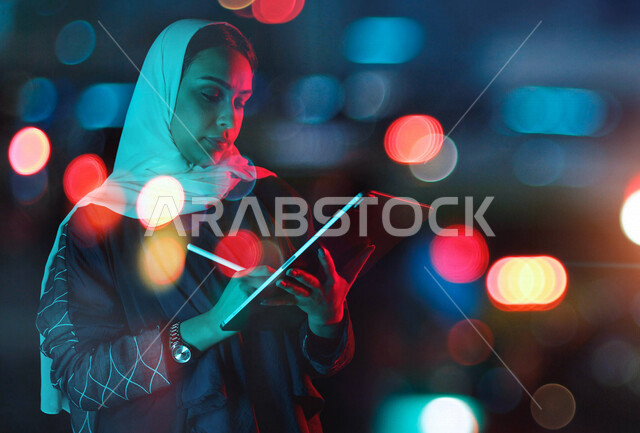 سيدة اعمال عربية خليجية سعودية تدون البيانات والملاحظات على جهاز التابلت  ، التسويق الالكتروني ، العمل عن بعد ، التعليم الالكتروني ، التواصل مع الاصدقاء ، استخدام التقنيات الحديثة في انجاز المهام 