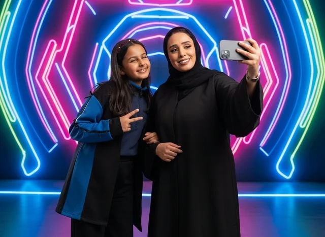 Saudi Woman and Girl Taking Selfie in Neon Light