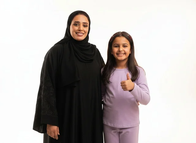 أم وابنة سعودية تبتسمان على خلفية بيضاء
