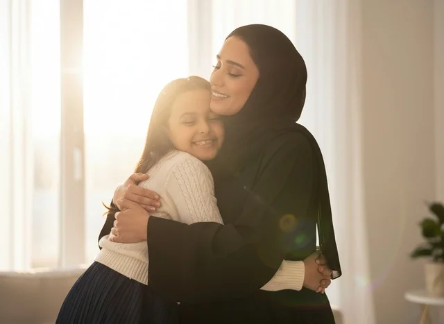 أم عربية تحتضن ابنتها بالعباءة والحجاب تحت ضوء الشمس أم عربية تحتضن ابنتها بالعباءة والحجاب تحت ضوء الشمس