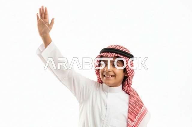 طفل سعودي بالثوب التقليدي يلوح بيده على خلفية بيضاء