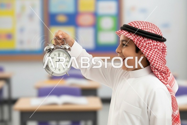 طالب سعودي في الفصل يحمل ساعة تنبيه