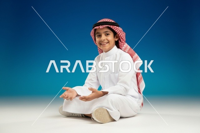 طفل سعودي بالثوب التقليدي خلفية زرقاء