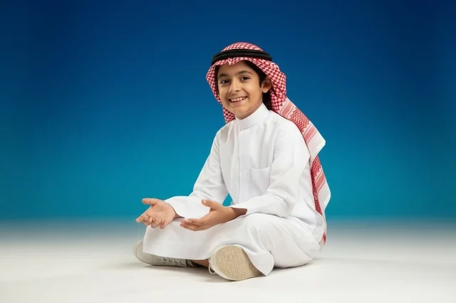 طفل سعودي بالثوب التقليدي خلفية زرقاء