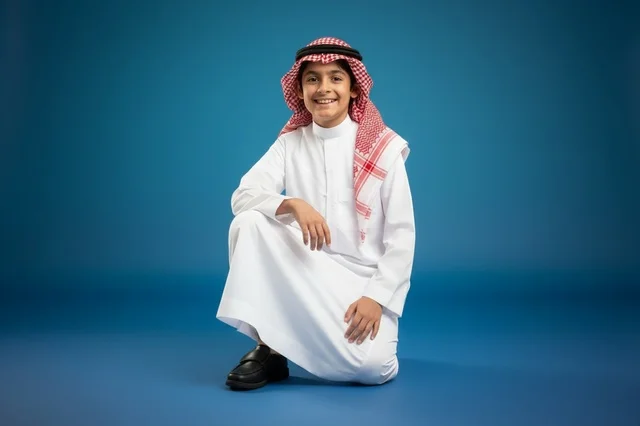 Saudi Boy in Traditional Thobe and Shemagh on Blue Background