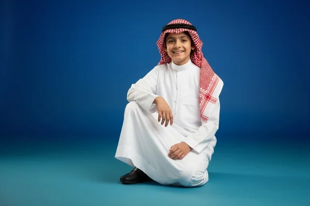 Saudi Boy in Traditional White Thobe and Red Shemagh Saudi Boy in Traditional White Thobe and Red Shemagh