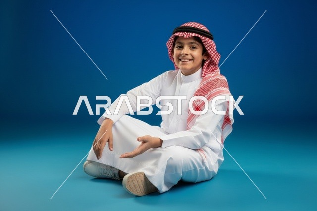 طفل سعودي بالزي التقليدي على خلفية زرقاء