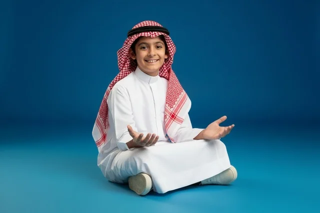 طفل سعودي بالزي التقليدي فوق خلفية زرقاء