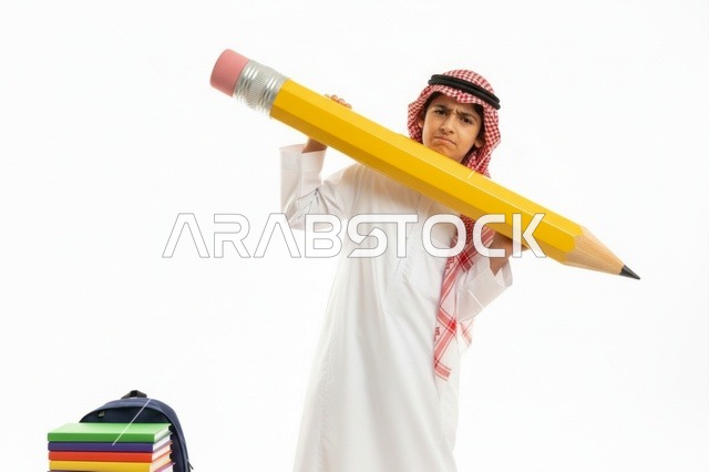 طفل سعودي بالزي التقليدي يحمل قلم رصاص ضخم