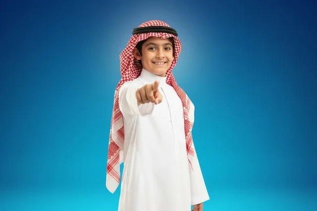 Saudi Boy in Traditional Thobe Pointing at Camera