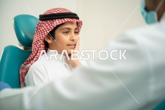 طفل سعودي يعاني من ألم الأسنان في عيادة الطبيب