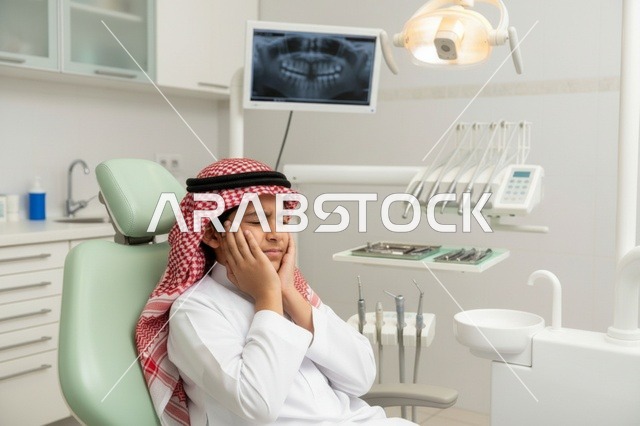 طفل سعودي يعاني من ألم الأسنان في العيادة