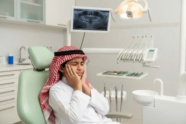 طفل سعودي يعاني من ألم الأسنان في العيادة