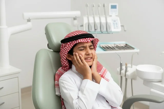 طفل سعودي في عيادة الأسنان يشعر بالألم