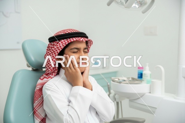 طفل سعودي يعاني من ألم الأسنان في العيادة