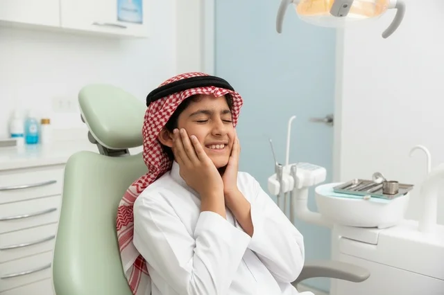 طفل سعودي يعاني من ألم الأسنان في العيادة