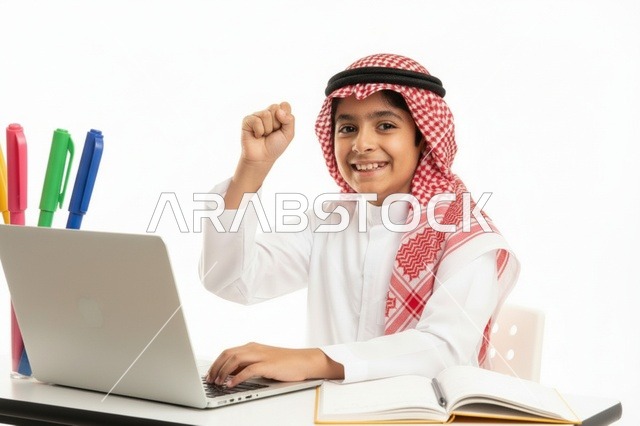 طفل سعودي يستخدم الحاسوب المحمول ويحتفل بالنجاح في الدراسة