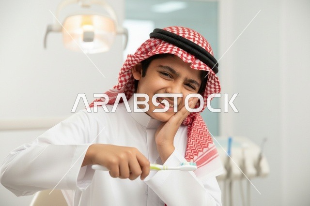 فتى سعودي يعاني من ألم الأسنان في عيادة طبية