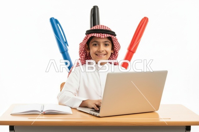طفل سعودي يستخدم الحاسوب المحمول بالزي التقليدي