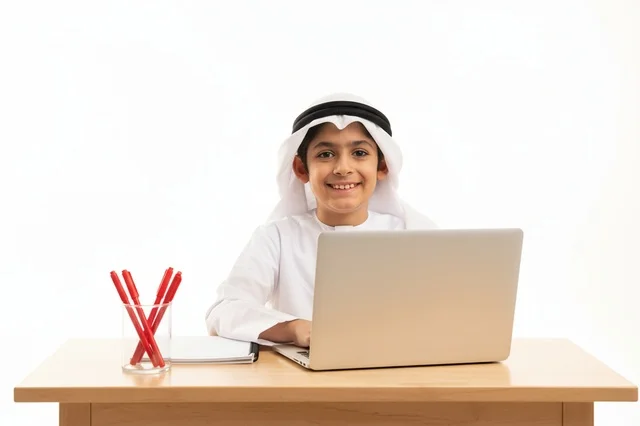 طفل إماراتي يستخدم الحاسوب المحمول على خلفية بيضاء