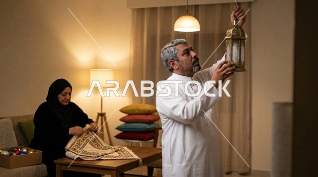 رجل سعودي يعلق فانوس رمضان في المنزل