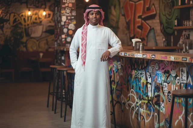 رجل سعودي بالزي التقليدي في مقهى عصري