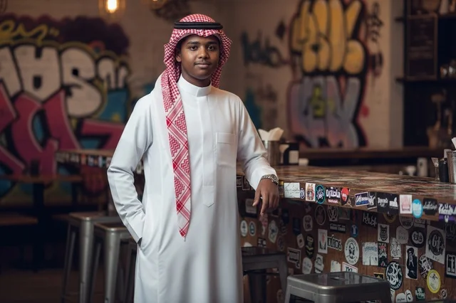 Saudi Man in Traditional Thobe at Modern Cafe