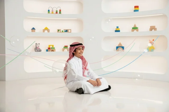 طفل سعودي باللباس التقليدي مع الألعاب