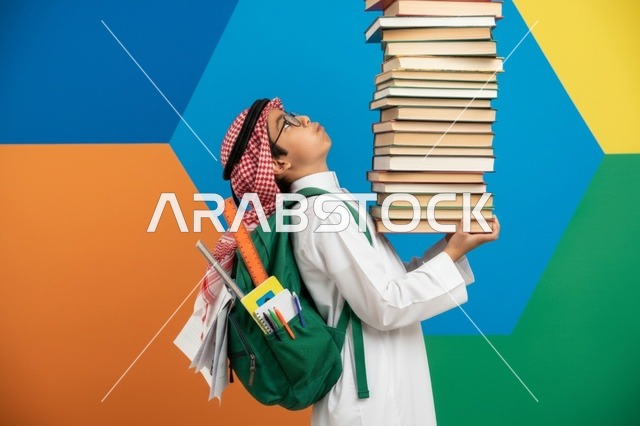 طالب سعودي يحمل كومة كتب كبيرة في الاستوديو