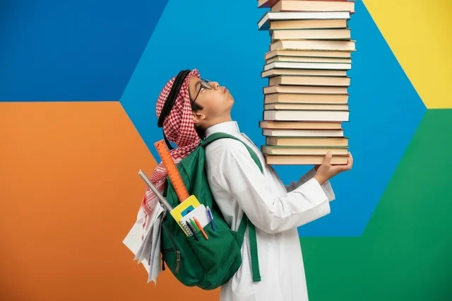 طالب سعودي يحمل كومة كتب كبيرة في الاستوديو