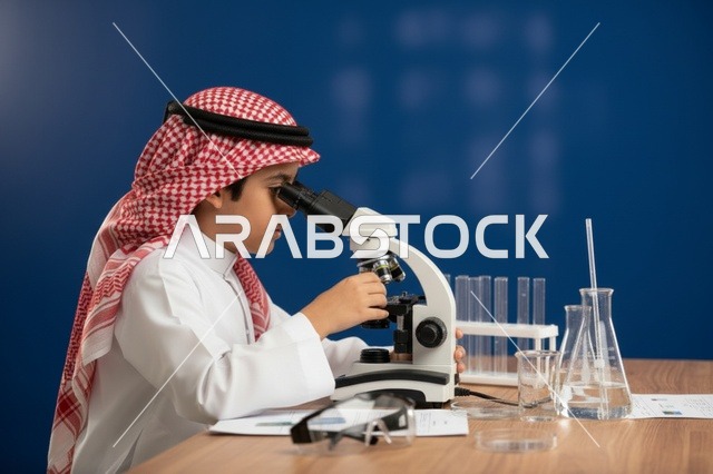 طفل سعودي يستخدم المجهر في مختبر العلوم