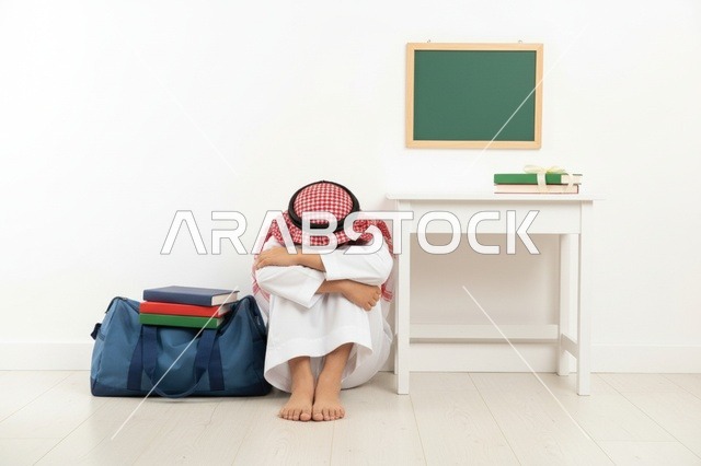 طالب سعودي حزين يجلس على أرضية الفصل الدراسي