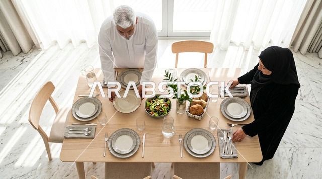 Elderly Emirati Couple Setting Dining Table at Home